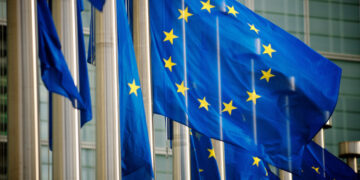 EU flags fly in a row in front of the European Commission